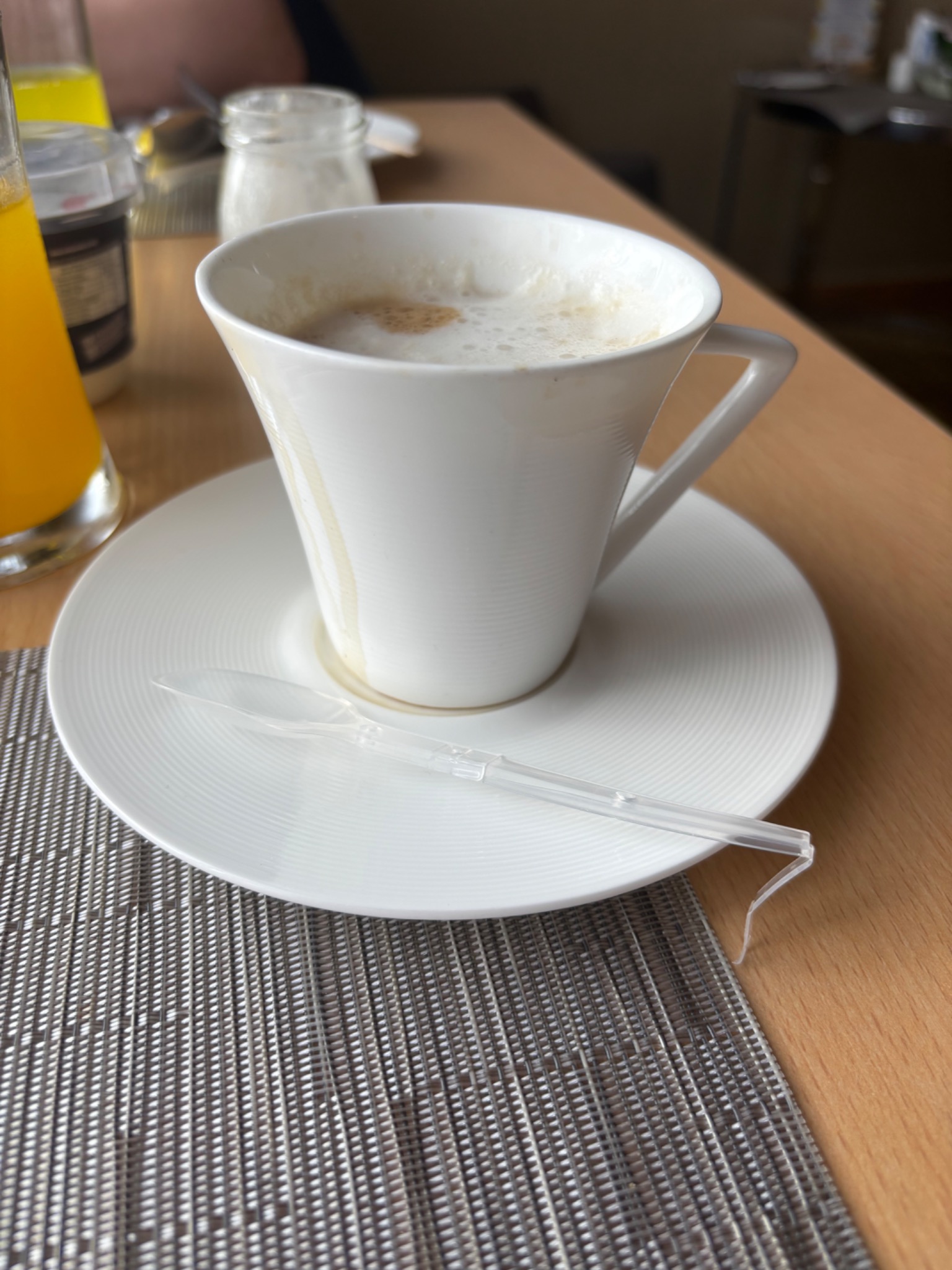 Cup of coffee served with a folding plastic spoon